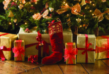 Christmas presents in gift-wrap, under a traditional tree.