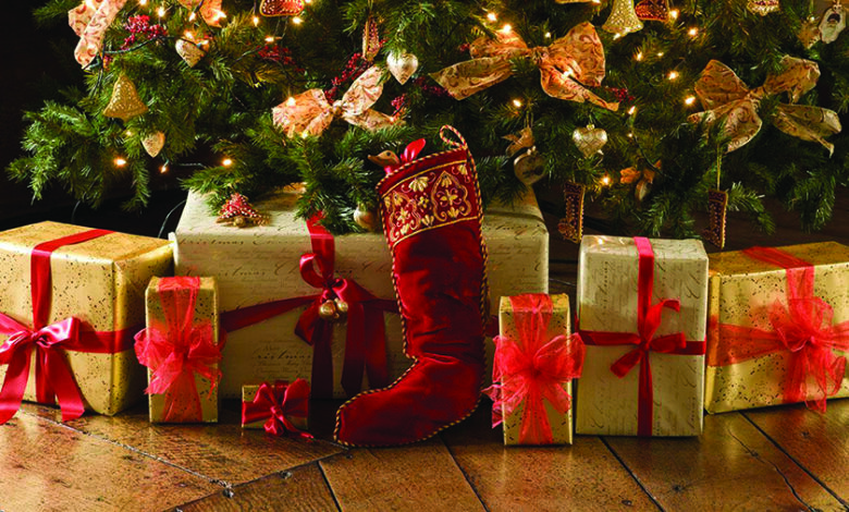 Christmas presents in gift-wrap, under a traditional tree.
